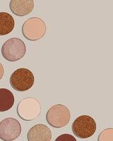 Frame with eye shadow beige brown natural color on neutral background with copyspace. Shiny and matte swatches of eyeshadows powder for make up, minimal style photo pastel colored, above view