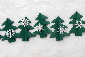 Christmas tree paper cutting, winter holiday background. Handmade origami green fir decorated snowflakes on white fur. Aesthetic top view, minimal flat lay trend pattern, Happy holidays concept photo