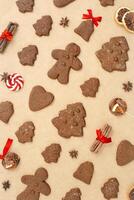 Christmas gingerbread cookies or biscuits on baking paper, winter seasonal traditional bakery with spices, dry orange, cinnamon sticks, anis, candy. Top view sweet food pattern, new year flatly photo
