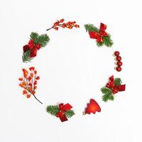 Christmas round frame from natural green fir branches and small red glitter balls and berries o photo