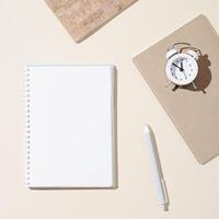 Autumn working space with open notebook with blank pages and white clock show day time. Autumnal time and mood concept. photo