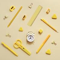 Alarm clock shows 8 oclock in morning, time to go to school concept. Flat lay with stationary school supplies photo