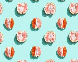 Pattern with red without peel orange or grapefruit on bright turquoise. Minimal summer fruits concept. photo