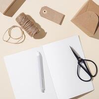 Open notebook with blank pages and craft paper box decorated natural autumn plant poppy. Autumnal concept photo