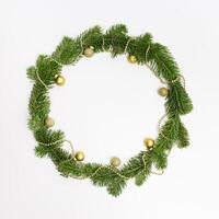 Christmas wreath or holiday decorative frame from green fir tree branches and golden small glitter balls photo