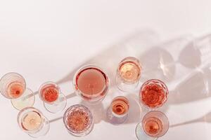 Various glasses of rose wine or champagne sweet and dry, top view. Light alcohol sparkling drink for parties photo