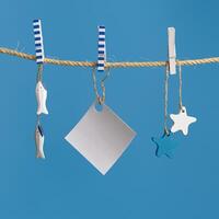 Marine or nautical themed background, summer sea toys lifeline, starfish and small fish hanging on blue color. photo