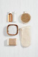 Spa setting for body care and beauty treatment. Bottles with gel and shampoo, soap, sea salt, washcloth for bath. photo