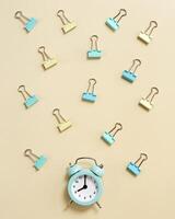 Alarm clock rings at 8 oclock in morning, time to go to school concept. Flat lay with clock and paper clips photo