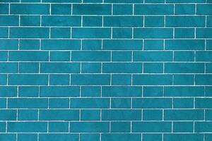 Brick wall is bright blue colored, texture of stone blocks, background of bricks. photo