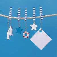Nautical concept with sea lifestyle decorations hanging on rope. Sea toys lifeline, seastars and small fish photo