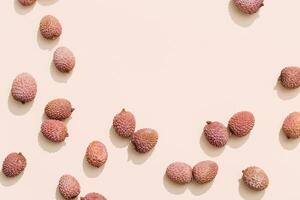 Fresh Lychee fruit on pastel beige background. Minimal fruit and summer concept. photo