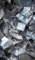Abstract composition of reflective metal shards creating a textured surface with bright light and dark shadows photo
