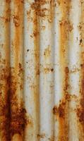 Detailed close up capturing the textures and patterns of an aged rusty corrugated metal surface showing degradation photo