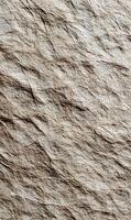Detailed close up of textured beige crumpled paper showcasing intricate folds and subtle variations in light and shadow photo