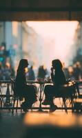 Two women enjoying conversation at outdoor cafe creating warm ambiance with blurred city backdrop and soft lighting photo