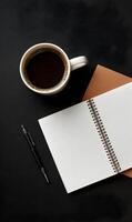 Elevated morning routine featuring aromatic coffee alongside an open notepad on a sleek black surface inviting focus and inspiration for the day ahead photo