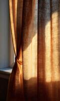 Golden light filters through a textured curtain creating an inviting warm atmosphere in the room space photo