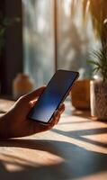 Modern connection a human hand holding a sleek smartphone with a sunlit background casting warm light rays photo