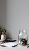Savings in a glass jar near notebook and pencils for financial growth and investment planning future photo
