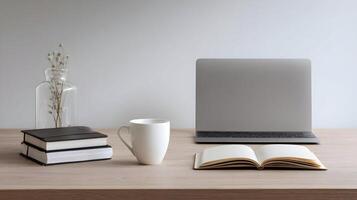 Serene workspace featuring a laptop, open notebook, coffee mug, books, and a vase with dry flowers photo