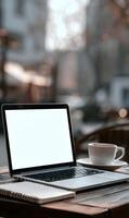 Laptop and coffee cup create a workspace atmosphere inviting relaxation and productivity in a cafe setting photo