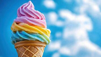 Rainbow ice cream cone against a blue sky photo