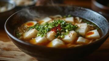 Hearty, steaming bowl of noodle soup photo