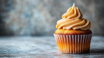 Delicious light golden cupcake with caramel frosting photo