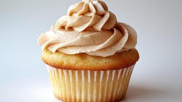 Delicious vanilla cupcake with a swirl of caramel frosting photo