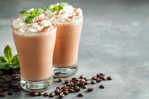 Two glasses of chocolate milkshake with whipped cream and mint leaves photo