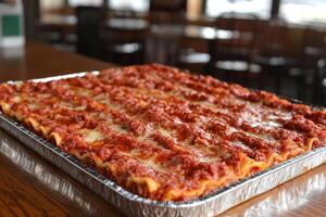 A large lasagna in a metal pan on a table photo