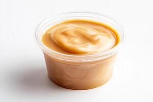 A plastic container of peanut butter on a white surface photo
