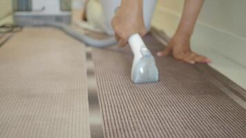 Cleaning a rug while using a vacuum cleaner indoors video