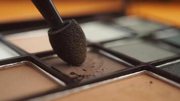 Applying makeup with a brush on an eyeshadow palette video