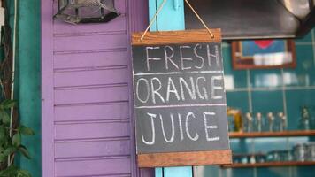 Fresh orange juice sign at local cafe in vibrant setting video