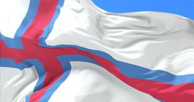 Flag of the Faroe Islands waving at wind with blue sky in slow, loop video