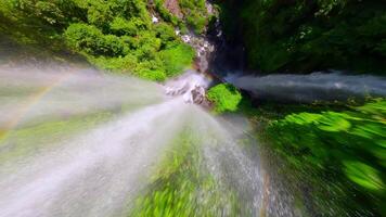 FPV drone shot soaring above the splashing Sekumpul Waterfall in Bali, Indonesia, rising from the water surface with cinematic movement and tropical scenery. video