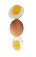 Top view of raw chicken egg and peeled cooked or boiled egg with egg yolk in two halves in stack isolated with clipping path in file format png