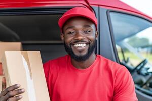 A smiling black man holding a box and smiling photo