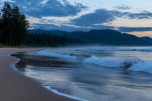 A beach with waves and a mountain in the background photo