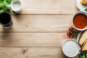 A wooden table with a bowl of soup, bread and a cup of coffee photo