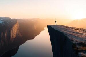 A man standing on the edge of a cliff overlooking a river photo