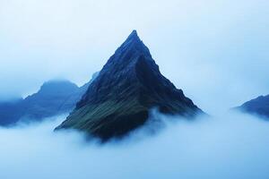 A mountain is surrounded by fog and clouds photo
