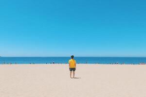 A man standing on the beach looking at the ocean photo