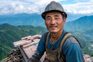A man in a hard hat sitting on top of a mountain photo