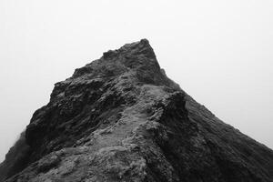 Black and white photo of a mountain in the fog