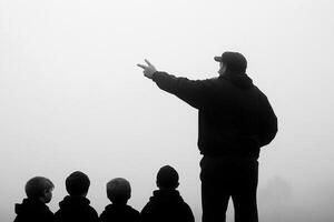 A man pointing at a group of children photo