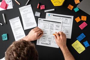A man is working on a document with sticky notes photo
