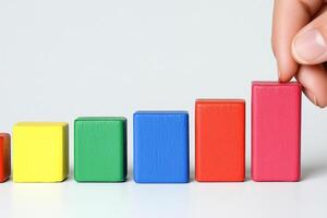 A person is holding a wooden block with colorful blocks photo